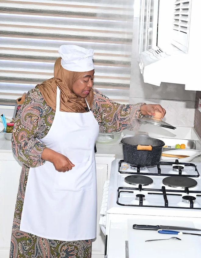 A cook preparing a meal on a clean gas burner in Tanzania